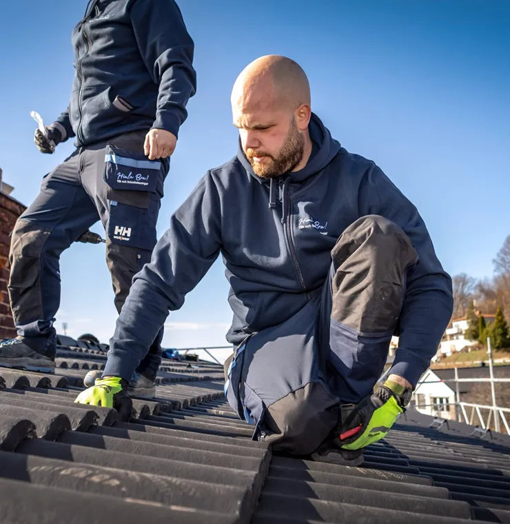 2 takläggare utför takbyte uppe på ett tak