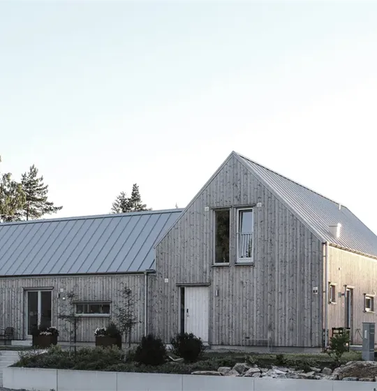 Plåttak med bandtäckning i ljust minimalistiskt utförande på trähus