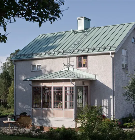 Plåttak med bandtäckning i vacker ljusgrön nyans på en villa