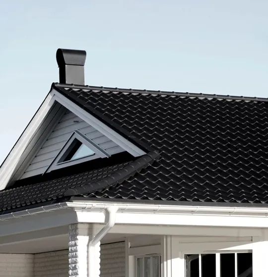 Nytt tak med snyggt Takpanneplåt i svart färg på hus